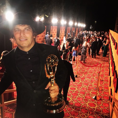 Nathan Ross, Emmy-winning producer, holding his Emmy Award on the red carpet
